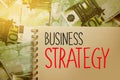 Business Strategy words written on copybook page on Hundred Euro bills banknotes background. Strategical management Concept