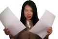 Business stress portrait of young attractive upset and stressed executive Asian Korean woman tired and unhappy holding paperwork Royalty Free Stock Photo