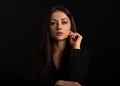 Business strong thinking woman with natural makeup looking with hand near the face arms in black t-shirt on dark shadow black Royalty Free Stock Photo