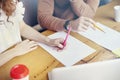 Business Student meeting in office, close-up of woman man hands writing on paper sheet, empty space for layout. Stationary on wood