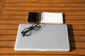 Empty white notepad with mobile phone, laptop and sight glasses Royalty Free Stock Photo