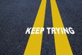 Keep trying word with yellow line marking on road surface