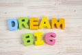 DREAM BIG  word on wooden desk over blue background Royalty Free Stock Photo