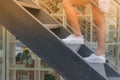 Business Success Concept : Woman is walking up black metal stairs outside the buildings. Royalty Free Stock Photo