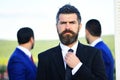 Business success and confidence concept. Businessman with beard adjusts tie