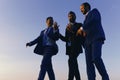 Business, success and cooperation concept. Company leaders take a walk on sunset sky background