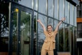 Business success - Happy young business woman celebrating work career achievements with both hands up against office building Royalty Free Stock Photo