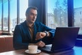 A business surprised man businessman a stylish of Caucasian appearance in a jacket, works in a laptop or computer, sitting at a Royalty Free Stock Photo