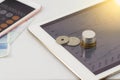 Business on tablet with coins and calculator on white background