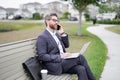 Business talk. Businessman talk on phone sitting on a bench in park. Businessman in suit call phone outside. Businessman Royalty Free Stock Photo