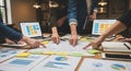 Business team analyzing data on laptops and papers at a meeting Royalty Free Stock Photo
