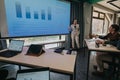 Business team analyzing data during a presentation in a modern classroom setting Royalty Free Stock Photo