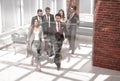 Business team, businesspeople group walking at modern bright office interior