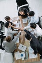 Business team colleague hands joining together in the meeting room office from top view