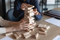 Business team colleagues playing jenga board game together