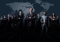 Business team formed of young businessmen standing over a dark background. Royalty Free Stock Photo