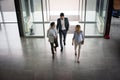 Business team gets to work. Three people entering the building. Royalty Free Stock Photo