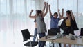 The business team got up and danced happily after achieving their team goals.