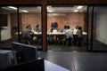 Business Team Having Late Night Meeting Sitting Around Boardroom Table