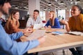 Business Team Having Meeting Sitting Around Table In Modern Open Plan Office Royalty Free Stock Photo