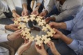 Business team holding and connecting parts of jigsaw puzzle to show concept of teamwork Royalty Free Stock Photo