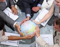 Business team holding a terrestrial globe