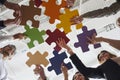 Business team joining jigsaw puzzle pieces and suggesting creative solutions to problem Royalty Free Stock Photo