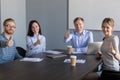 Business team looking at camera showing thumbs up at meeting Royalty Free Stock Photo