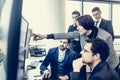 Business team looking at data on multiple computer screens in corporate office. Businesswoman pointing on screen Royalty Free Stock Photo