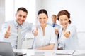 Business team showing thumbs up in office