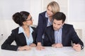 Business team sitting around a table in a meeting talking together. Royalty Free Stock Photo