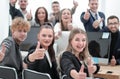 Business team sitting at a Desk and showing thumbs up