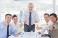 Business team smiling at camera showing thumbs up Royalty Free Stock Photo