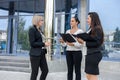 Business team with tablets posing outside office building. Three ladies looking directly on tablet screen Royalty Free Stock Photo