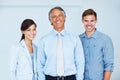 Business team of three smiling. Portrait of smiling business team with happy mature business man leading. Royalty Free Stock Photo