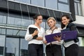 Business team. Three women in suits with folders and tablet posing outside building Royalty Free Stock Photo