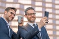 Business team. Two handsome young businessman using phone and standing on the street outdoor. Portrait of a smiling Royalty Free Stock Photo