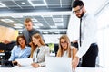 Business team is working on a new project and smiling while sitting at their desk in a modern office to discuss the project Royalty Free Stock Photo