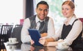 Business team working on tablet pc together in a cafe Royalty Free Stock Photo