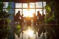 Business team working together at office, sunset view from window. Royalty Free Stock Photo