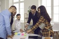 Business team writes notes on colored sticky stickers while discussing a startup project. Royalty Free Stock Photo