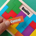 Business Teamwork Concept- Hand holding orange wooden puzzle with text CONTROL and QUALITY Royalty Free Stock Photo