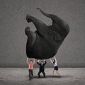 Business teamwork lifting elephant on grey Royalty Free Stock Photo