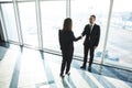 Business, teamwork, partnership, cooperation and people concept - business people shaking hands over panoramic office Royalty Free Stock Photo