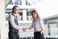 Business, teamwork, partnership, cooperation and people concept. Business people shaking hands over panoramic office windows Royalty Free Stock Photo