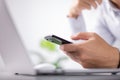 Business and technology concept, freelancer, programmer using smart mobile phone while working on laptop computer