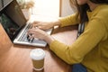 Digital lifestyle working outside office. Woman hands typing laptop computer with blank screen on table in coffee shop.