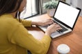 Woman hands typing laptop computer with blank screen on table in coffee shop. Blank laptop screen mock up for display of design. Royalty Free Stock Photo