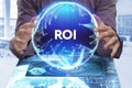 Business, Technology, Internet and network concept. Young businessman shows the word on the virtual display of the future: ROI