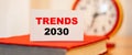 Business text - Trends 2030 on the background of the clock